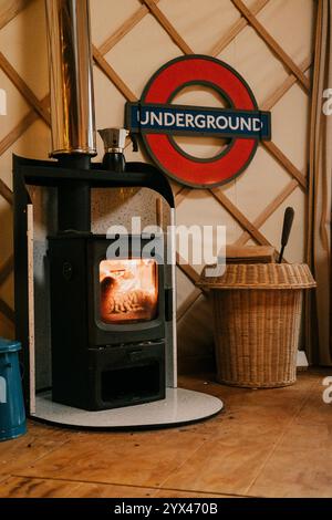 Ein Holzofen steht vor einem Schild mit der Aufschrift Underground. Der Herd ist angezündet und das Feuer brennt hell Stockfoto