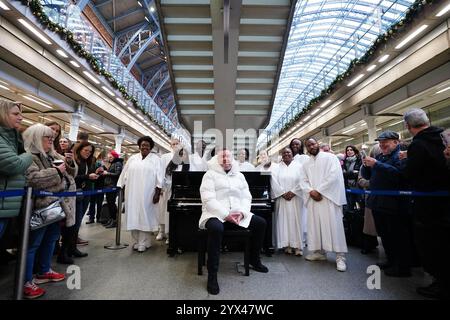 Tony Mortimer überrascht Pendler am St Pancras International Station in London mit einem Pop-up-Auftritt seiner Nummer eins zu Weihnachten 1994, „Stay Another Day“, unterstützt vom London Community Gospel Choir. Tony arbeitet mit der Musiktherapie-Wohltätigkeitsorganisation Nordoff und Robbins zusammen, um den 30. Jahrestag der Veröffentlichung des Songs zu feiern. Bilddatum: Freitag, 13. Dezember 2024. Stockfoto