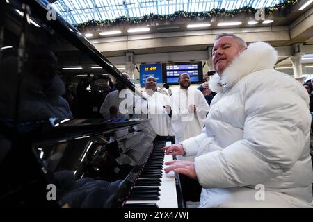 Tony Mortimer überrascht Pendler am St Pancras International Station in London mit einem Pop-up-Auftritt seiner Nummer eins zu Weihnachten 1994, „Stay Another Day“, unterstützt vom London Community Gospel Choir. Tony arbeitet mit der Musiktherapie-Wohltätigkeitsorganisation Nordoff und Robbins zusammen, um den 30. Jahrestag der Veröffentlichung des Songs zu feiern. Bilddatum: Freitag, 13. Dezember 2024. Stockfoto