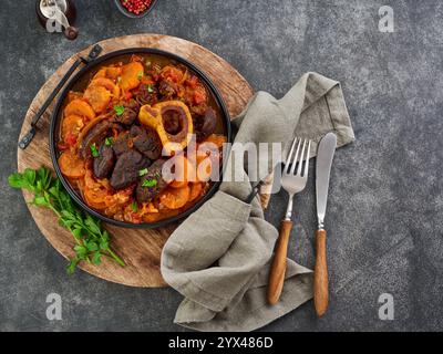 Ossobuco. Steak Kalbsbacken oder Eintopf mit Gemüsesauce und Gewürzen auf einem alten Betontisch Hintergrund. Italienische Küche Hintergrund mit Zutaten. Stockfoto