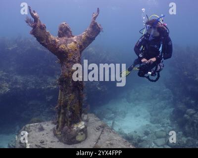 Taucher mit Blick auf die Statue von Jesus Christus unter Wasser (Christus des Abgrunds), Tauchplatz John Pennekamp Coral Reef State Park, Key Largo, Florida Keys Stockfoto