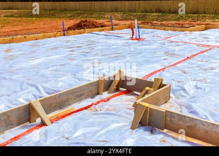 Bei der Vorbereitung des Fundaments für den Neubau am Standort ist ein überdachter Bereich mit Kunststoff-Schutzvorrichtungen und Holzrahmen umgeben Stockfoto