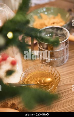 Flüssiger Honig in einer Glasschale und Mehl auf dem Tisch, Zutaten für Weihnachtskekse Stockfoto