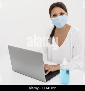 Frau mit medizinischer Maske Handdesinfektionsmittel Stockfoto