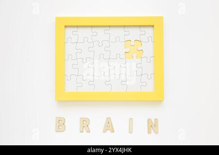Gelber Rahmen mit fehlendem Puzzleteil in der Nähe des Hirnworts Stockfoto