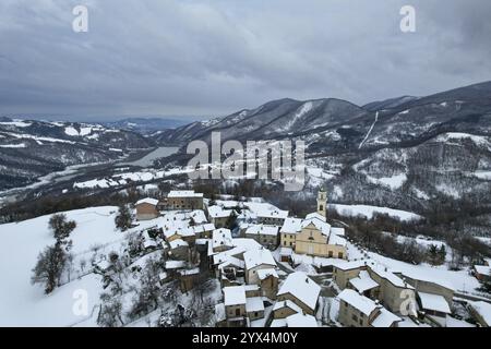 Blick aus der Vogelperspektive auf Vezzolacca, ein kleines Dorf im ligurischen apennin, das im Winter von Schnee bedeckt ist Stockfoto