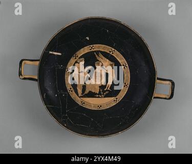 Dachboden Rotfigur Kylix, ca. 410 v. Chr. Weinbecher mit Demonassa und Peitho. Weitere Informationen: Peitho, die Göttin der Überredung, spricht eine Frau namens Demonassa an, die in einer felsigen Landschaft sitzt und ziemlich niedergeschlagen aussieht. Rechts legt ein kleiner geflügelter Eros, der Gott der Liebe, seine Hand auf Demonassas Schulter, was das Thema der Botschaft von Persuasion deutlich macht. In der griechischen Mythologie gab Aphrodite, die Göttin der Liebe, Demonassa an Phaon, einen Fährmann auf der Insel Lesbos, im Gegenzug für einen Dienst, den er für die Göttin geleistet hatte. Dieser Becher ist ein ungewöhnlich gutes Beispiel für die Division o Stockfoto