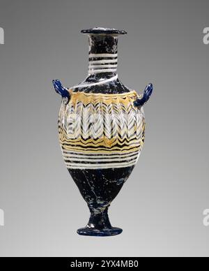 Kerngebildete dunkelblaue Amphoriskos, 3. Bis 1. Jahrhundert v. Chr. Zusätzliche Info: Blaue Parfümflasche mit flachem Rand, weißem Faden am Hals und gekämmtem Dekor (gelb und weiß) am Körper. Zwei kleine vorstehende Griffe. Stockfoto