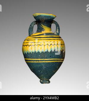 Amphoriskos, 6.-4. Jahrhundert v. Chr. Parfümflasche mit Zickzack. Zusätzliche Info: Kernförmige, dunkelblau-grüne Amphoriskos. Feine Streifen aus deckendem Gelb und Türkis schlängelten horizontal um das Stück, dann in der Vertikalen gekämmt, um ein gefiedertes Muster im Mittelteil zu bilden, das geglättet und durch Marvering in die Oberfläche eingearbeitet wurde. Nachdem das Kernmaterial entfernt wurde, wurden die Griffe als Spuren aus geschmolzenem blauem Glas an den Seiten der Halterungen angebracht, nach oben gezogen und wieder am Hals befestigt. Der Rand wurde hinzugefügt und außen ein gelbes Band hinzugefügt. Der Fuß war Stockfoto