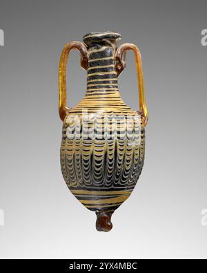 Amphoriskos, 2.-1. Jahrhundert v. Chr. Rote und gelbe Kolben mit Festoons. Zusätzliche Info: Kernförmige, dunkelbläulich-schwarze Amphoriskos mit einem gekämmten Muster in Gelb und weiß. Ein Faden aus gelben Spiralen zieht sich um den Hals und endet am Rand des Mundes. Das untere Gehäuse ist ebenfalls mit einem spiralförmigen gelben Gewinde verziert, das in einem Knauf aus klarem braunem Glas endet. Zwei braune Griffe, einer auf jeder Seite, erstrecken sich vom Hals und werden an der Schulter befestigt. Das Gefäß ist in gutem Zustand und weist einige Anzeichen von Verwitterung und Verfärbung auf. Es gibt ein kleines Loch in der Nähe der Basis und Stockfoto