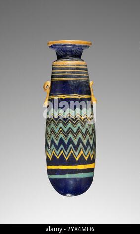 Alabastron, 200-1 v. Chr. Blaue Parfümflasche mit Zickzack. Zusätzliche Info: Kern geformt: Ein Kern aus organischen und anorganischen Materialien, der am Ende eines Stabes nach den Abmessungen des Innenraums geformt ist. In eine Reihe von geschmolzenem dunkelblauem Glas getaucht oder das Glas um das Äußere gezogen und dann glatt marvertiert. Feine Bänder aus deckendem gelbem und türkisfarbenem Glas wurden dann horizontal um das Stück gezogen, dann senkrecht in den mittleren Körper des Stücks gekämmt, wobei sich abwechselnd ein Federmuster bildete, das dann durch Marvering in das Gewebe des Stücks eingearbeitet wurde. Das Kernmaterial wurde dann entfernt Stockfoto