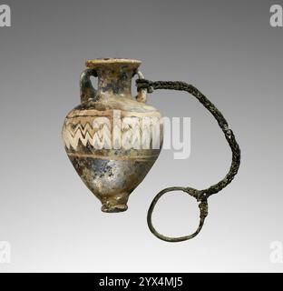 Amphoriskos, 6.-4. Jahrhundert v. Chr. Blaue Parfümflasche mit angeschlossener Kette. Zusätzliche Info: Kernförmige, dunkelblaue Amphoriskos, verziert mit einem gekämmten, deckenden gelben, weißen und braunen Zickzack-Muster um den Körper. An einem der Griffe ist ein Kettenglied aus Bronze befestigt, das in einem Ring endet. Die Oberfläche befindet sich in einem schlechten Zustand, wobei der Großteil der Oberfläche durch eine undurchsichtige Schimmelbildung verdeckt ist. Stockfoto