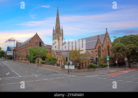 Historische Kirche mit einem hohen Turm unter einem lebhaften Abendhimmel, eingerahmt von Bäumen und ruhigen Straßen im Jahr 2015 Stockfoto