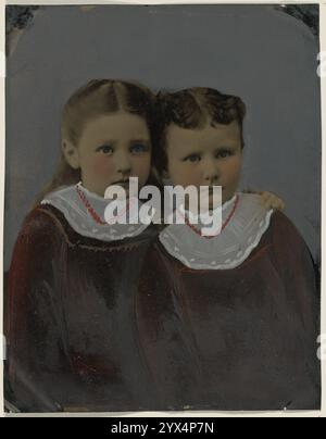 Porträt zweier Mädchen, 1860er-1880er Jahre Porträt zweier Mädchen in passenden dunklen Kleidern mit weißen Spitzenkragen und roten Ketten. Ein Mädchen hat lange Haare, das andere hat kurze Haare. Stockfoto