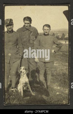 Männer und Hund, 1915-1930. Drei Männer stehen für ein Porträt mit einem weiß gefleckten Hund zu ihren Füßen. Stockfoto