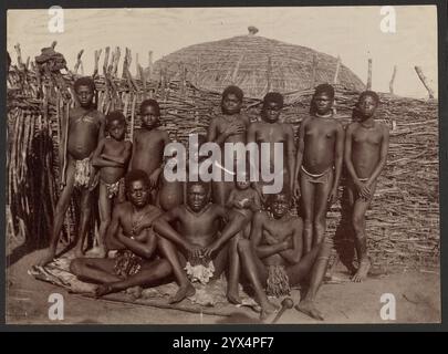 Junger Zulus, etwa 1860-1880. Gruppenporträt junger Zulu-Jungen. Drei ältere Jungen sitzen auf dem Boden, während die jüngeren Jungen hintereinander stehen. Die Gruppe steht vor einem Zaun aus Holzstäben. Die Spitze einer runden Hütte ist Stockfoto