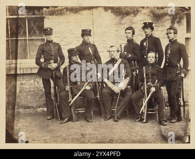 Elliotts Amtszeit, The Old Cadets, 1859. Gruppenporträt von Kadetten aus dem Addiscombe-Seminar. Drei Männer sitzen und haben Schwerter umhüllt und hängen an ihren Gürteln. Die Kadetten sind alle mit Gewehren besetzt. Stockfoto