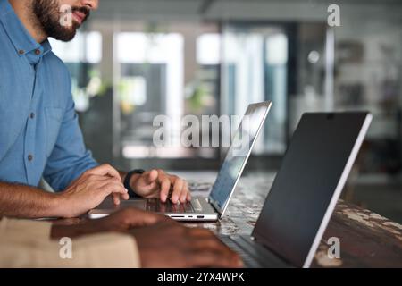 Berufsleute, zwei männliche Angestellte, die Computer benutzen, die im Büro arbeiten. Stockfoto