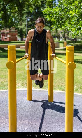 Junger Mann, der an parallelen Außenstangen eintaucht. Stockfoto