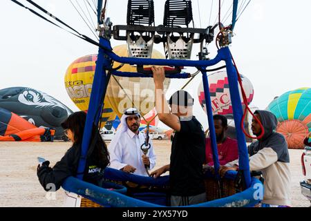 Doha, Katar. Dezember 2024. Die Teilnehmer bereiten einen Heißluftballon während des Qatar Balloon Festival 2024 in Doha, Katar, am 13. Dezember 2024 vor. Die 5. Ausgabe des Qatar Balloon Festivals findet hier vom 12. Bis 22. Dezember statt, an dem mehr als 50 Teilnehmer teilnehmen. (Foto: Noushad Thekkayil/NurPhoto) Credit: NurPhoto SRL/Alamy Live News Stockfoto