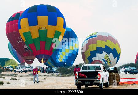 Doha, Katar. Dezember 2024. Die Teilnehmer bereiten einen Heißluftballon während des Qatar Balloon Festival 2024 in Doha, Katar, am 13. Dezember 2024 vor. Die 5. Ausgabe des Qatar Balloon Festivals findet hier vom 12. Bis 22. Dezember statt, an dem mehr als 50 Teilnehmer teilnehmen. (Foto: Noushad Thekkayil/NurPhoto) Credit: NurPhoto SRL/Alamy Live News Stockfoto