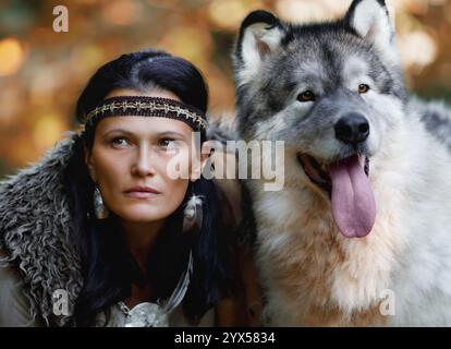 Porträt einer jungen charmanten Frau mit einem Alaska Malamute Hund im Wald vor dem Hintergrund der Natur Stockfoto