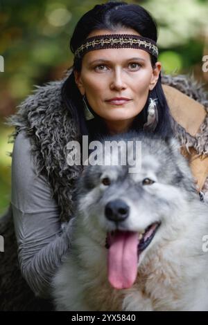 Porträt einer jungen hübschen Frau mit einem Alaska Malamute Hund im Wald vor dem Hintergrund der Natur Stockfoto