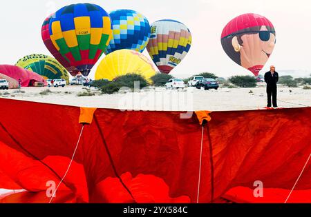 Doha, Katar. Dezember 2024. Die Teilnehmer bereiten einen Heißluftballon während des Qatar Balloon Festival 2024 in Doha, Katar, am 13. Dezember 2024 vor. Die 5. Ausgabe des Qatar Balloon Festivals findet hier vom 12. Bis 22. Dezember statt, an dem mehr als 50 Teilnehmer teilnehmen. (Foto: Noushad Thekkayil/NurPhoto) Credit: NurPhoto SRL/Alamy Live News Stockfoto