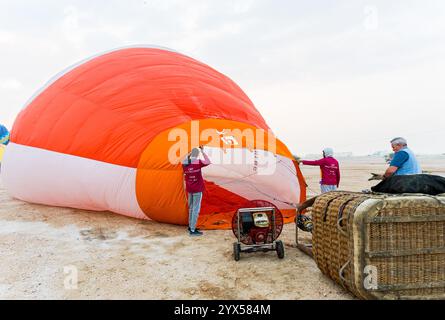 Doha, Katar. Dezember 2024. Die Teilnehmer bereiten einen Heißluftballon während des Qatar Balloon Festival 2024 in Doha, Katar, am 13. Dezember 2024 vor. Die 5. Ausgabe des Qatar Balloon Festivals findet hier vom 12. Bis 22. Dezember statt, an dem mehr als 50 Teilnehmer teilnehmen. (Foto: Noushad Thekkayil/NurPhoto) Credit: NurPhoto SRL/Alamy Live News Stockfoto