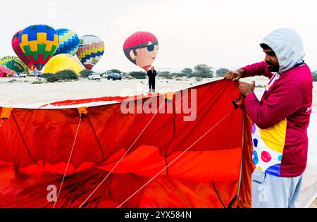 Doha, Katar. Dezember 2024. Die Teilnehmer bereiten einen Heißluftballon während des Qatar Balloon Festival 2024 in Doha, Katar, am 13. Dezember 2024 vor. Die 5. Ausgabe des Qatar Balloon Festivals findet hier vom 12. Bis 22. Dezember statt, an dem mehr als 50 Teilnehmer teilnehmen. (Foto: Noushad Thekkayil/NurPhoto) Credit: NurPhoto SRL/Alamy Live News Stockfoto
