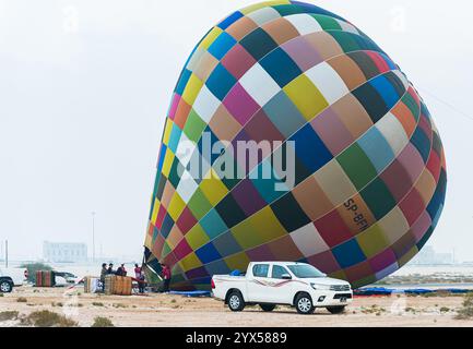 Doha, Katar. Dezember 2024. Die Teilnehmer bereiten einen Heißluftballon während des Qatar Balloon Festival 2024 in Doha, Katar, am 13. Dezember 2024 vor. Die 5. Ausgabe des Qatar Balloon Festivals findet hier vom 12. Bis 22. Dezember statt, an dem mehr als 50 Teilnehmer teilnehmen. (Foto: Noushad Thekkayil/NurPhoto) Credit: NurPhoto SRL/Alamy Live News Stockfoto