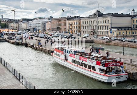 Helsinki, Finnland, 18. Juli 2024: Touristen steigen in helsinki an Bord eines Sightseeing-Bootes, mit Marktplatz und Präsidentenpalast im Hintergrund Stockfoto