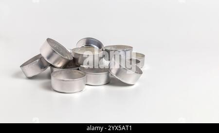 Gebrauchte Teelichter-Tassen aus Aluminium isoliert auf weißem Hintergrund mit Kopierraum Stockfoto
