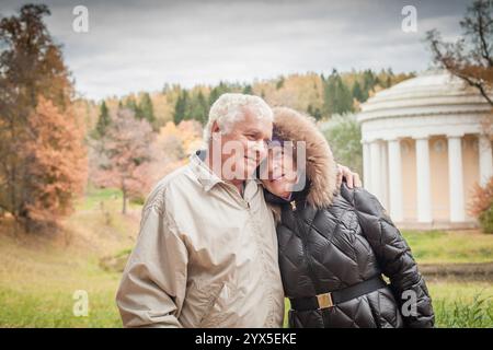 Liebevolles Paar, Seniorenmann und Frau, die sich im Herbstpark umarmen Stockfoto