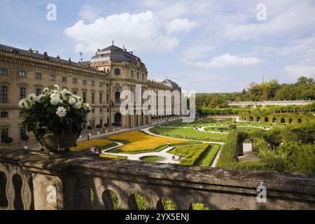 Hochwinkelansicht des Parterre mit orangefarbenen Blumenrändern in der Bischofsresidenz und im Hofgarten im Spätsommer, Würzburg, Deutschland. Stockfoto