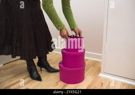 Stapel von drei pinkfarbenen Geschenkkartons auf Holzboden. Stockfoto