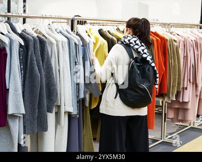 Frau entscheidet, Kleidung im Store. Stockfoto