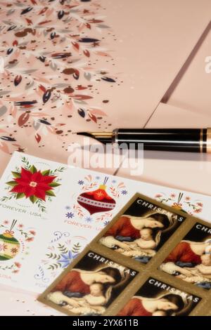 Stilleben von Weihnachtskarten und Briefmarken während der Weihnachtszeit im Dezember 2024, USA Stockfoto