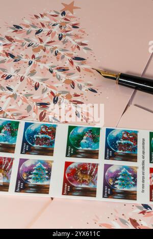 Stilleben von Weihnachtskarten und Briefmarken während der Weihnachtszeit im Dezember 2024, USA Stockfoto