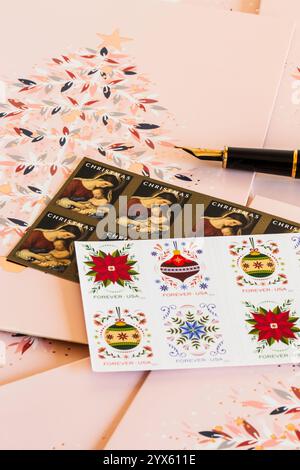 Stilleben von Weihnachtskarten und Briefmarken während der Weihnachtszeit im Dezember 2024, USA Stockfoto