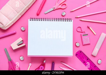 Notizbuch- und Federmäppchen mit verschiedenen Schreibmaterialien auf pinkfarbenem Hintergrund Stockfoto