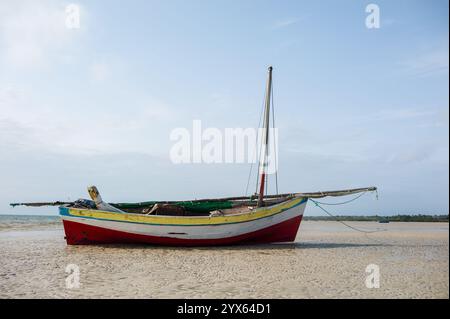 Traditionelles hölzernes Dhow-Segelboot liegt am Strand bei Ebbe, Vilanculos, Provinz Inhambane, Mosambik. Stockfoto