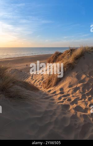 Dieses Bild fängt das Wesen des Sommers ein und blickt an einem schönen Sommerabend von einer Lücke in den Sanddünen am Formby Beach auf das Meer Stockfoto