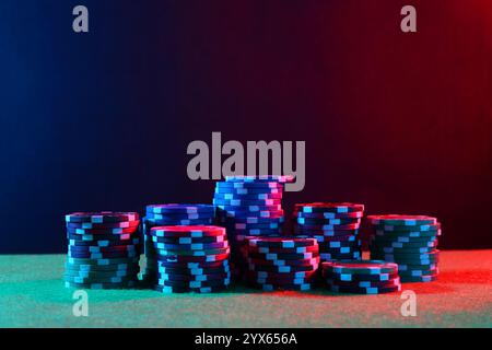 Pokerspiel. Casino Chips auf grünem Tisch in Neonlichtern Stockfoto