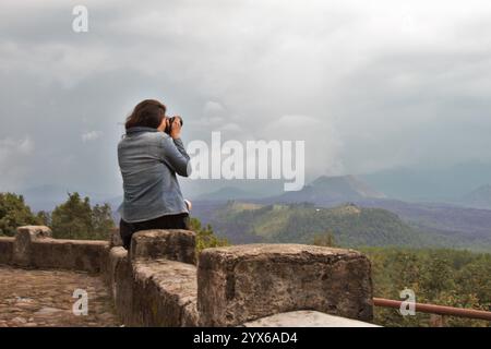 Eine Frau fotografiert eine bergige Landschaft. Stockfoto