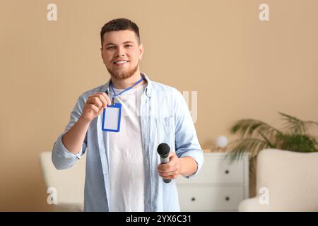 Männlicher Reporter mit Mikrofon und leerem Namensschild im Studio Stockfoto