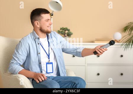 Reporter mit Mikrofon und leerem Namensschild, der im Studio interviewt Stockfoto