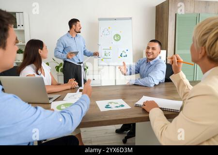 Männlicher Ingenieur mit Windkraftanlagenmodell, der seine Kollegen im Büro vorstellt Stockfoto