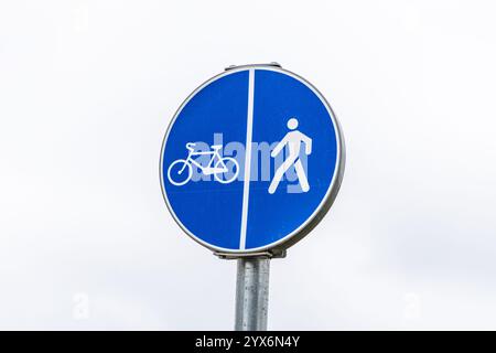 Schild für Fahrrad- und Fußgängerwege isoliert gegen grauem Himmel. Zeichen für Rad- und Wanderwege. Stockfoto