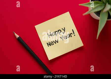 Happy New Years geschrieben mit einem Stift auf einem Post-it auf rotem Hintergrund Stockfoto